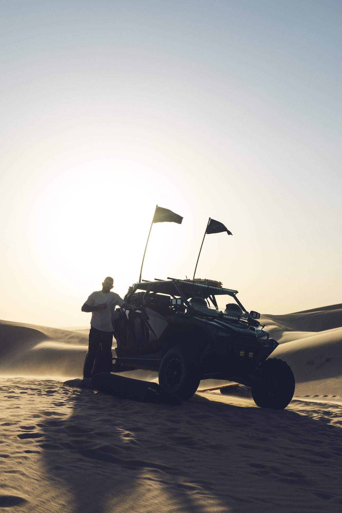 Off-road vehicle silhouetted on the dunes
